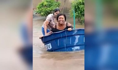Em Goiás: Moradora usa caixa d'água como barco em rua alagada