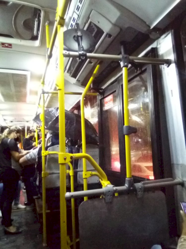 Passageiro abre guarda-chuva dentro do ônibus por causa de goteiras