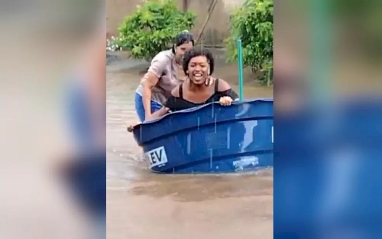 Em Goiás: Moradora usa caixa d'água como barco em rua alagada